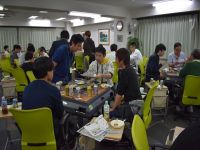 暴走祭（懇親会）の様子途中成績などを手にチーム名やクイズなどをみんなと相談