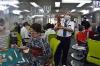 闘牌する鈴木 寿佳子と伊勢海老で写真に写る土屋 政士支部長